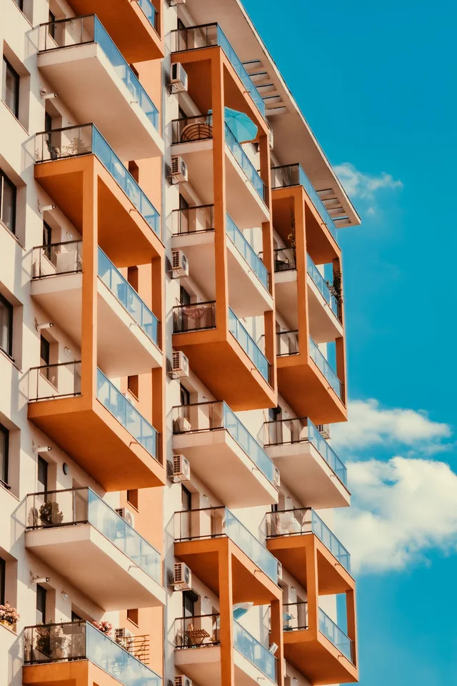 Illustrative warm-toned residential building with glass balconies
